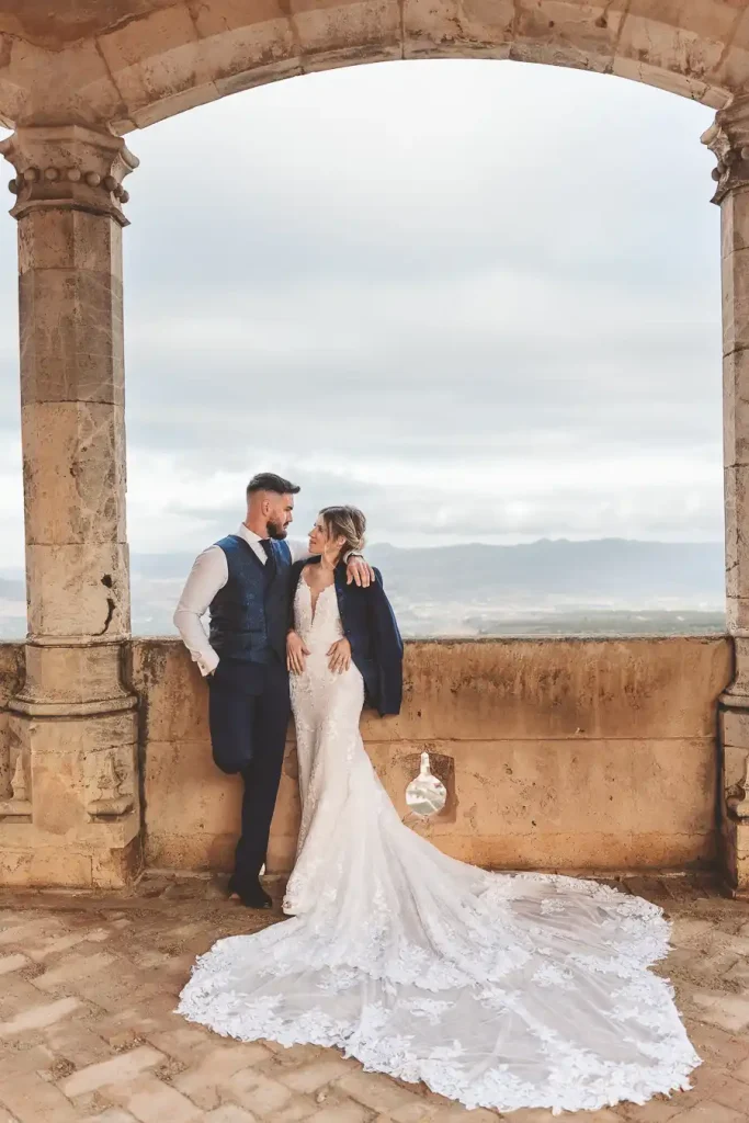 Novios posando en ventana del castillo – postboda en Almería