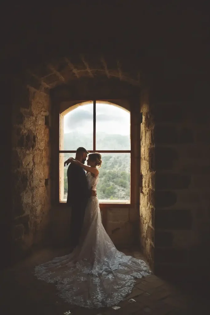 Postboda con luz natural – pareja en ventana del castillo
