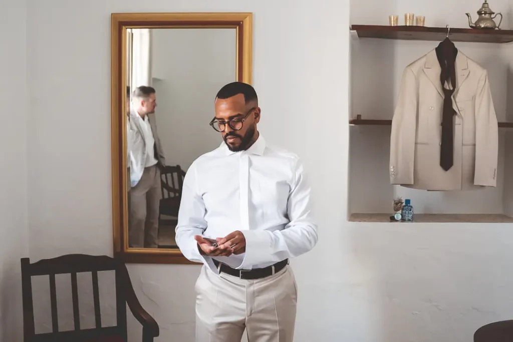 Preparativos del novio antes de la ceremonia mirando sus gemelos