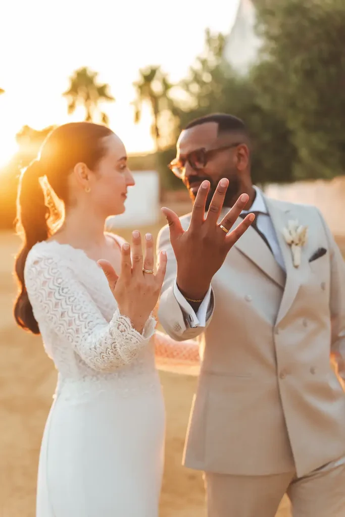 Novios con sus anillos en señandolos a cámara