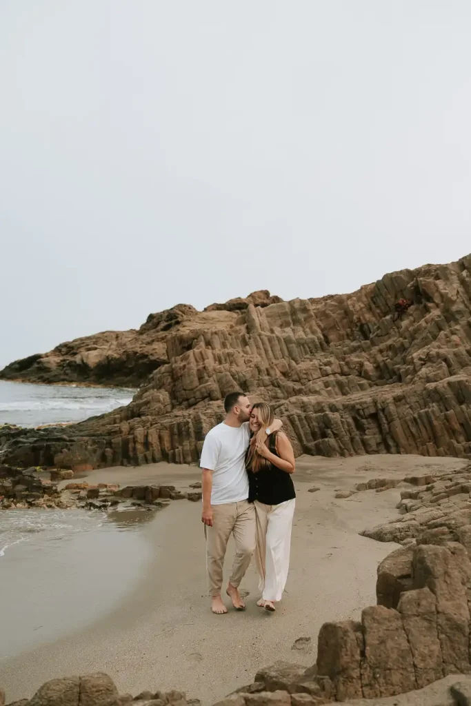 Marta y Álvaro caminando por la playa durante su preboda