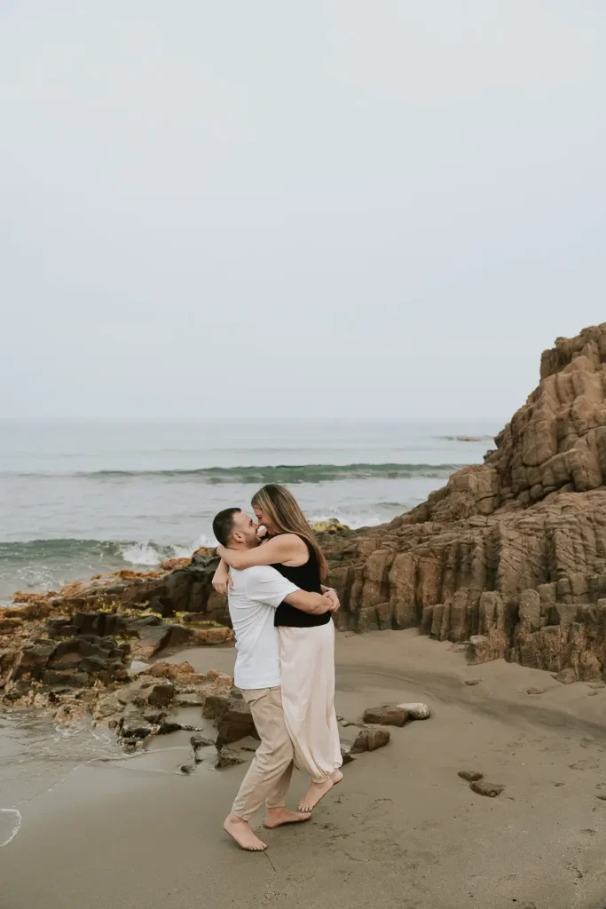 Pareja abrazada entre las rocas durante su sesión preboda